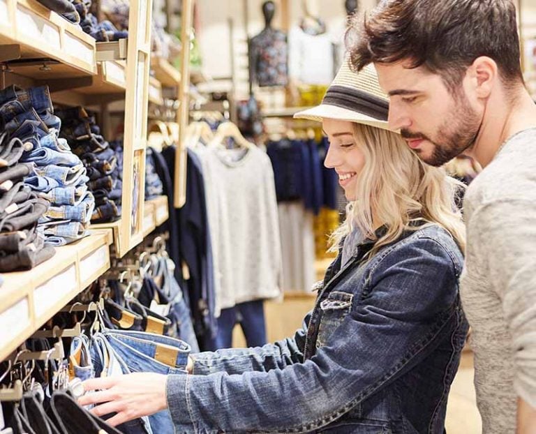A couple looking at jeans in a shop
